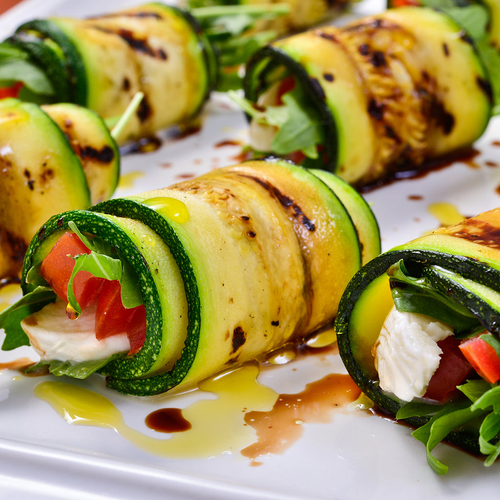 Grilled zucchini with tomato arugula and mozzarella cheese drizzled with olive oil and Jomeis Sweet Balsamic Reduction